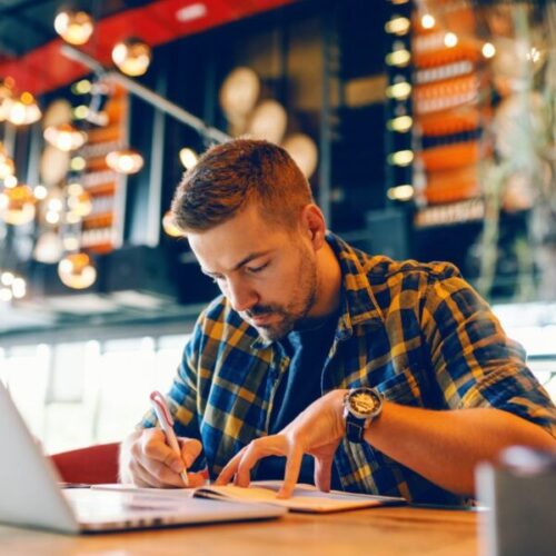 Portrait Of Mature Businessman Working On Laptop At Desk In Office
